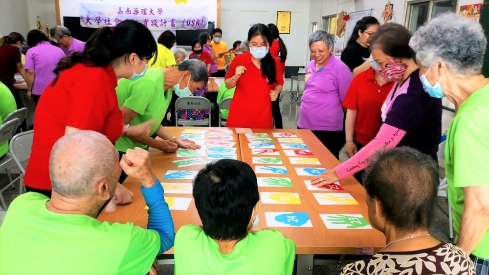 嘉藥林秀碧老師帶領學生與老人一起玩桌遊。
(位置在第二段)